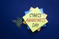 Stress Awareness Day symbol. Yellow steaky note with words Stress Awareness Day. Beautiful deep blue background. Business and