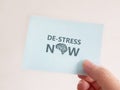 Stress Awareness. Holding a note with the words De-Stress Now Royalty Free Stock Photo