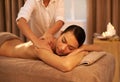 Stress be gone. A beautiful young woman enjoying a massage at the spa.