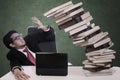 Stress businessman with falling books and copyspace