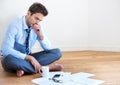 Stress, documents and finance with a business man reading tax paper or a budget on the floor of his apartment Royalty Free Stock Photo