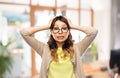 Asian woman in glasses holding to head at office Royalty Free Stock Photo