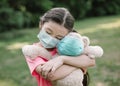 Stress little girl holding toy bear in medical protective mask Royalty Free Stock Photo