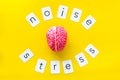 Stress and noise text with brain for psychological health in office concept on yellow background top view