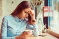 Stress. Portrait stressed sad young woman with coffee cup sitting in a trendy cafe coffee shop about to cry. City urban life style Royalty Free Stock Photo