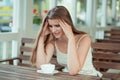 Sad young woman with coffee cup sitting on a trendy cafe Royalty Free Stock Photo