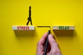 Stress or relax symbol. Wooden blocks with words `Stress, Relax`. Yellow background. Businessman hand, businesswoman icon.