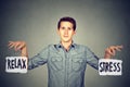 Stress or relax. Young man holding two signs Royalty Free Stock Photo