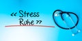 Stress Ruhe  Stress - Peacein German Sign.Text underline with red line. Isolated on blue background with stethoscope. Health Royalty Free Stock Photo