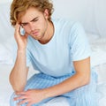 Stress, thinking and exhausted with a man on his bed in the morning to wake up feeling moody. Depression, mental health