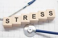 Stress word written on wooden blocks and stethoscope on light white background Royalty Free Stock Photo