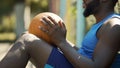 Stressed African American man sitting on ground after basketball game, sport Royalty Free Stock Photo