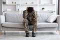 Stressed african american soldier in military uniform sitting on couch Royalty Free Stock Photo