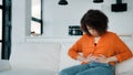 Stressed African American woman sitting on sofa touching belly ill sick biracial curly girl suffering from stomachache Royalty Free Stock Photo