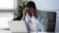 Stressed African worker touching temples feels unhealthy suffers from headache Royalty Free Stock Photo