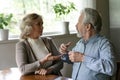 Stressed aged spouses sitting at table quarrelling with raised voices Royalty Free Stock Photo