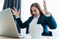 Stressed angry business woman screaming on laptop or notebook in office
