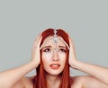 Stressed angry woman has temper tantrum, hand on head looking up tikka oriental jewelry on head. Isolated gray background Royalty Free Stock Photo