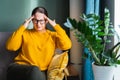 Stressed anxious middle-aged woman sitting on sofa suffering from headache Royalty Free Stock Photo