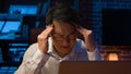 Stressed Asian businessman in glasses working with laptop at night in home office exhausted ill tired Korean middle-aged Royalty Free Stock Photo