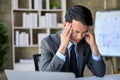 Stressed Asian businessman at his desk, worried about his business`s financial investment Royalty Free Stock Photo