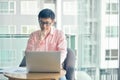 Stressed Asian businessman using laptop in living room