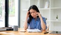 A stressed Asian businesswoman is feeling overwhelmed, trying to fix the problems over the phone