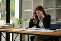 A stressed Asian businesswoman focuses on working on her business financial data reports Royalty Free Stock Photo