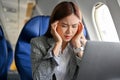 Stressed asian businesswoman suffering from headache and airsick during the flight Royalty Free Stock Photo