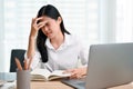 Stressed Asian businesswoman suffering from headache, worried or upset with her work Royalty Free Stock Photo