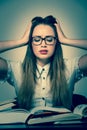 Stressed asian caucasian woman student learning in tons of books Royalty Free Stock Photo