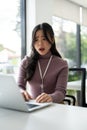 A stressed Asian female worker is having a problem installing programs on her laptop Royalty Free Stock Photo