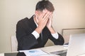 Stressed Asian male employee sitting in the office tired after overwork all night