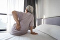 Stressed asian senior woman suffering from backache,sitting on bed massage her waist pain,unhappy old elderly people waking up in Royalty Free Stock Photo