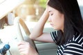 Stressed Asian woman driver sitting in car having headache stop after driving car in traffic jam.  Exhausted Japanese driver. Royalty Free Stock Photo