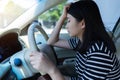 Stressed Asian woman driver sitting in car having headache stop after driving car in traffic jam.  Exhausted Japanese driver. Royalty Free Stock Photo