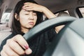 Stressed Asian woman driving car on the road suffering from headache and tired with traffic jam