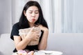 Asian woman holding bin in hand tries to vomit and diet after eating food, Bulimia nervosa, anorexia nervosa concept