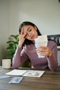 A stressed Asian woman worried about her monthly expenses while checking her electric bills Royalty Free Stock Photo