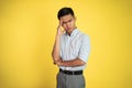 Stressed asian young young man holding head