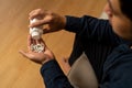 Stressed, asian young man, male holding medicine, pill or drug. Close up hand of abuse overdose pills and addict. Sick, pain of Royalty Free Stock Photo