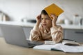 Stressed Black Boy Using Laptop And Covering Head With Workbook At Home Royalty Free Stock Photo