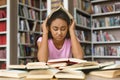 Stressed black girl student preparing for examination in library Royalty Free Stock Photo