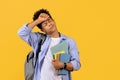 Stressed black student guy with books, overwhelmed by study load Royalty Free Stock Photo