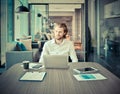 Stressed blonde business man using a laptop in living room at ni