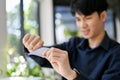 Stressed and broke young Asian man breaking his credit card, having financial problems Royalty Free Stock Photo