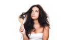 Brunette woman with wavy unruly hair in comb looking away isolated on white