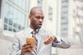 Stressed business man looking at wrist watch, running late for meeting outside corporate office Royalty Free Stock Photo