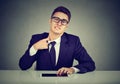 Stressed young business man pulling his shirt on his neck uncomfortable with too tight tie and formal wear