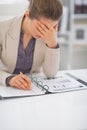 Stressed business woman with documents at work